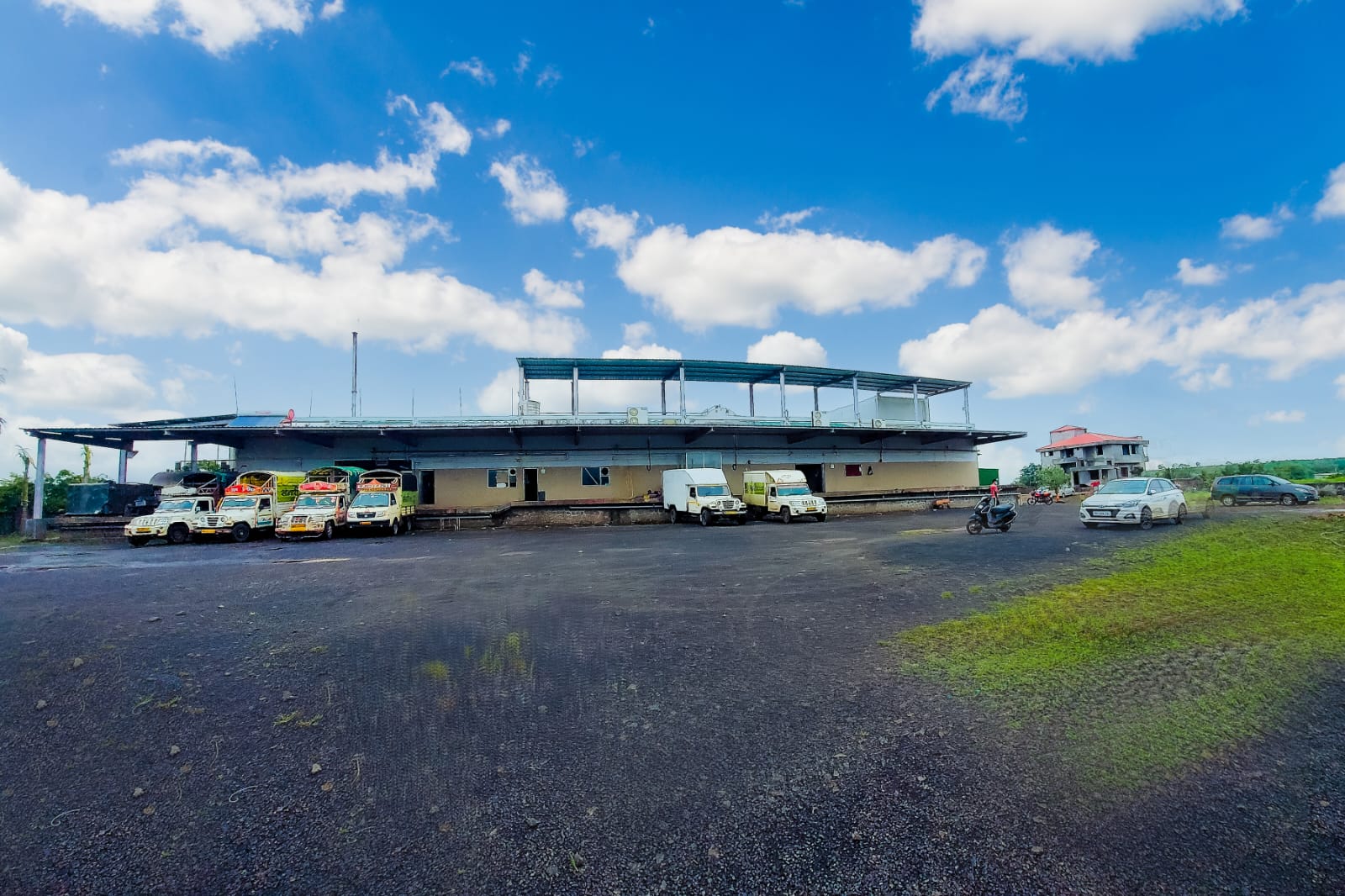 Wide exterior view of the Krrish-Dharah facility and delivery vehicles